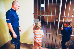 Policjanci oprowadzają małego chłopca po swojej komendzie