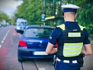 policja obok samochodu którym jechał zatrzymany mężczyzna