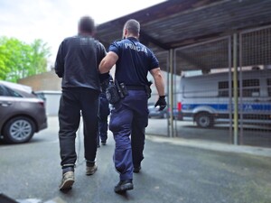 policjant prowadzi zatrzymanego