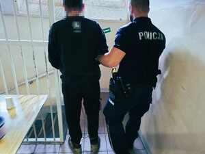 policjant prowadzi zatrzymanego