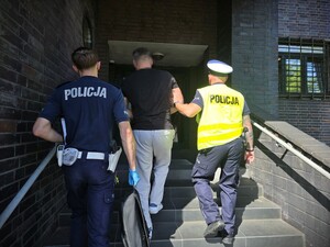 policjanci prowadzą zatrzymanego