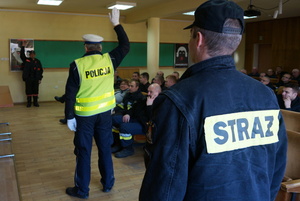 Policjant z wydziału ruchu drogowego szkoli strażaków w zakresie kierowania ruchem