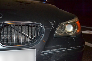 Widoczne lewe przednie naroże pojazdu z uszkodzeniami - zarysowaniami powłoki lakierniczej.