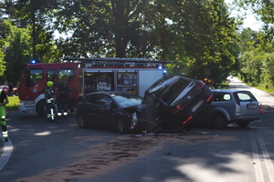 Na zdjęciu widoczne trzy samochody, które się zderzyły. Widoczny również wóz strażacki i strażacy.