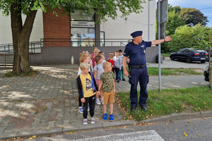 Umundurowany policjant prowadzi spotkanie z dziećmi.