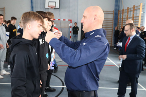 Na zdjęciu widoczny Komendant Powiatowy Policji w Zawierciu inspektor Jacek Kurdybelski, który wręcza zawodnikowi medal.