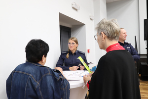 Na zdjęciu widoczna policjantka, która rozmawia z dwiema kobietami.