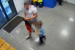 Na zdjęciu widoczny nieumundurowany policjant idący z dzieckiem w kierunku miejsc do siedzenia na terenie poczekalni zawierciańskiej jednostki Policji.