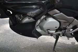 Na zdjęciu widoczny jest częściowo motocykl z otartymi elementami.