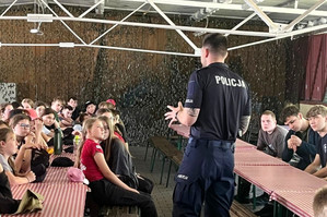 Na zdjęciu widoczny policjant podczas pogadanki dla obozowiczów.