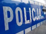 Na zdjęciu częściowo widoczne oznakowanie radiowozu - napis Policja.