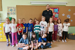 Na zdjęciu widoczny policjant z uczestnikami spotkania.