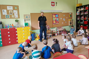 Na zdjęciu widoczny policjant z uczestnikami spotkania.