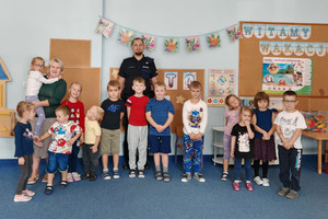 Na zdjęciu widoczny policjant z uczestnikami spotkania.