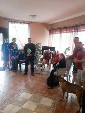 Na zdjęciu widoczny policjant z uczestnikami spotkania.