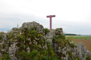 Na zdjęciu widoczny zniszczony krzyż, który stoi na skale.