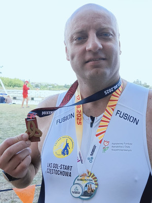 Na zdjęciu widoczny Zbigniew Adamowski trzymający w ręku medal.