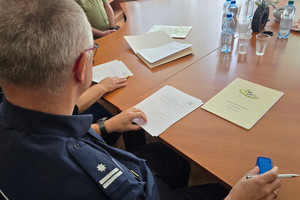 Na zdjęciu częściowo widoczny I Zastępca Komendanta Powiatowego Policji w Zawierciu podinspektor Paweł Sobota oraz leżący przed nim na stole dokument.