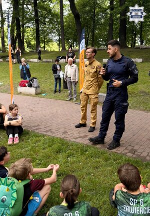 Policjant prowadzi pogadankę dla dzieci.
