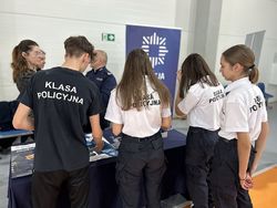 Na zdjęciu widać uczniów klasy policyjnej przed stanowiskiem promującym zatrudnienie w Policji.