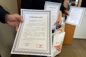 Na zdjęciu widać list gratulacyjny, który w dłoniach trzymają odznaczeni.