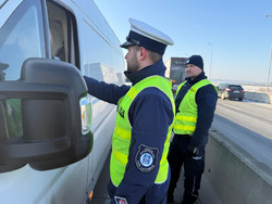 Na zdjęciu widać policjantów podczas akcji badania trzeźwości na węźle autostrady A1. Widać kontrolowane samochody osobowe i ciężarowe.