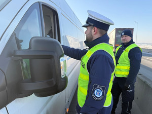 Na zdjęciu widać policjantów podczas akcji badania trzeźwości na węźle autostrady A1. Widać kontrolowane samochody osobowe i ciężarowe.