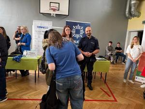Na zdjęciu widać targi pracy, policyjne stanowisko w tle oraz innych wystawców.