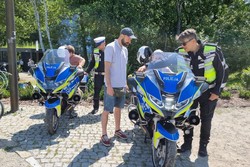 Na zdjęciu widać policyjne motocykle, policjantów oraz uczestników pikniku.