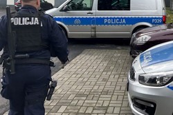 Na zdjęciu widać policjanta i policyjne radiowozy.