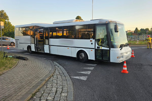 Na zdjęciu widać autobus oraz leżącą na chodniku hulajnogę.