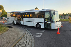 Na zdjęciu widać autobus oraz leżącą na chodniku hulajnogę.