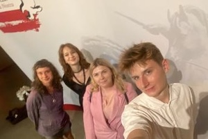 Na zdjęciu widać uczniów i opiekuna na wspólnym zdjęciu podczas gali finału konkursu historycznego.