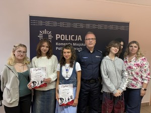 Na zdjęciu widać uczennice, nauczycielkę i I Zastępcę Komendanta na wspólnym zdjęciu.