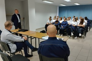 Na zdjęciu widać policjanta, prelegentów oraz uczestników debaty w zgromadzonych w sali odpraw żorskiej komendy Policji.