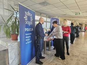 Na zdjęciu widać policjantów oraz dwie kobiety, które stoją przy promocyjnym stanowisku.