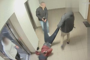 Na zdjęciu widać mężczyznę, którego ciągną po podłodze inne osoby.