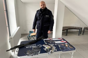 Na zdjęciu widać policjanta przed stanowiskiem promującym pracę w Policji.