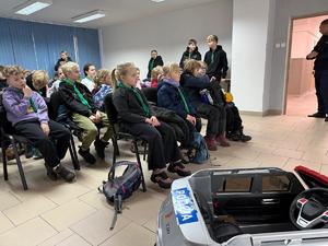 Na zdjęciu widać policjantów, zuchów i ich opiekunów podczas zwiedzania żorskiej komendy Policji.