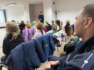 Na zdjęciu widać policjantów, zuchów i ich opiekunów podczas zwiedzania żorskiej komendy Policji.