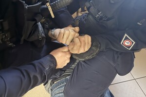 Na zdjęciu widać mężczyznę zakutego przez policjantów w kajdanki.