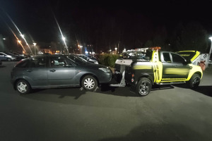 Na zdjęciu widać ciemny holowany samochód, a także autolawetę.