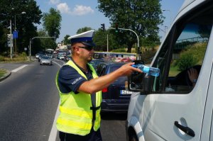 Policjant rozdający wodę