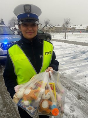 policjantka trzyma paczki dla dzieci