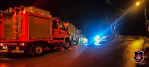zdjęcie zrobione nocą, ciemne przy drodze obok siebie stoją wozy strażackie
