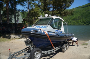 zdjęcie łódki z przodu podczepionej do wózka w tle jezioro i góry