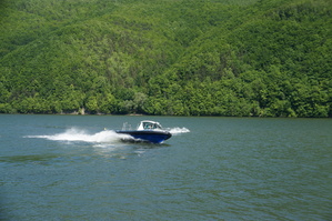 łódka pływająca na jeziorze w tle góry