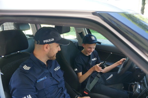 policjant i chłopak siedzą w radiowozie