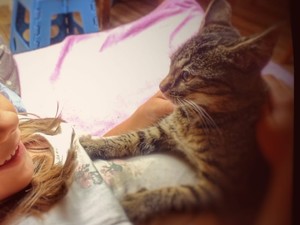 fragment dziewczynki która leży i trzyma kotka