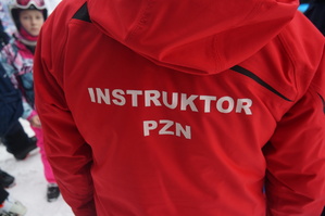 instruktor narciarstwa stoi tyłem na plecach ma napis instruktor PZN